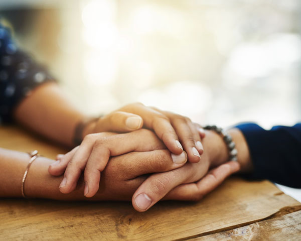 Close up image of two people holding hands