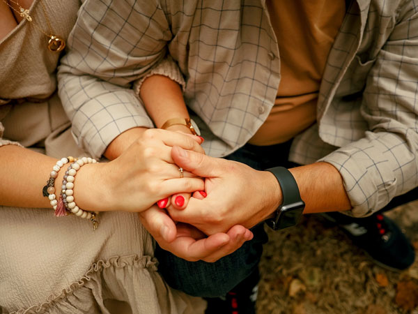 Image of two people holding hands close